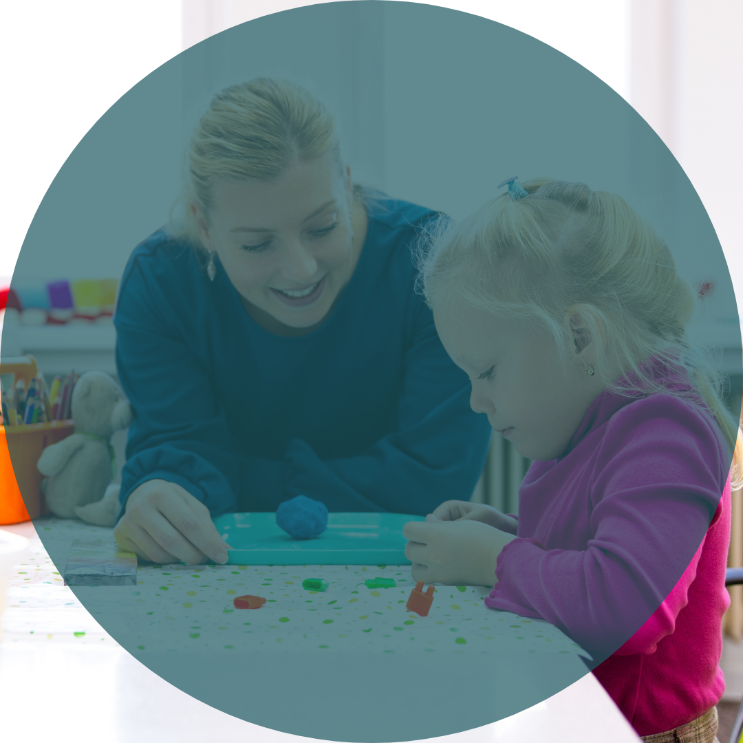 An older white woman with blonde hair in a ponytail and a blue shirt looks at a little girl as she plays with blue playdough. The little girl is also white with very light blonde hair done in a braid, she is smiling whole she works with the playdough. On top of the whole image is a teal overlay.