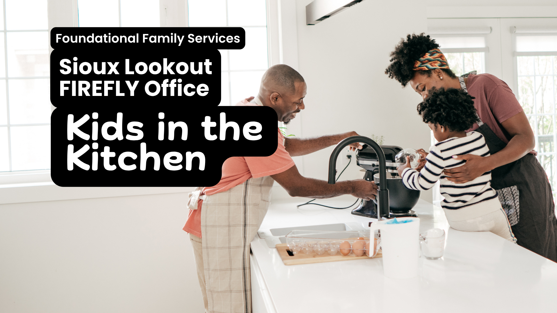 In white text overtop of a black box Foundational Family Services, Sioux Lookout FIREFLY Office, Kids in the Kitchen. The image behind the text is a black family smiling as they use a stand mixer together. A young child is sitting on the counter being supported by a woman, while a man stands on the other side of the counter holding the mixer.
