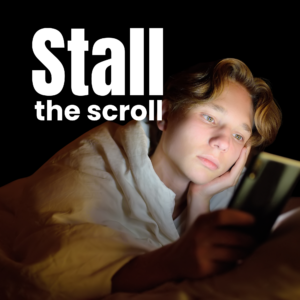 In large white text Stall the scroll on top of a dark background. An image is on top of the black background of a young man white white skin and light blonde hair that is wavy. The light from his phone is lighting up his face as he stares blankly at his screen in an ominous way.